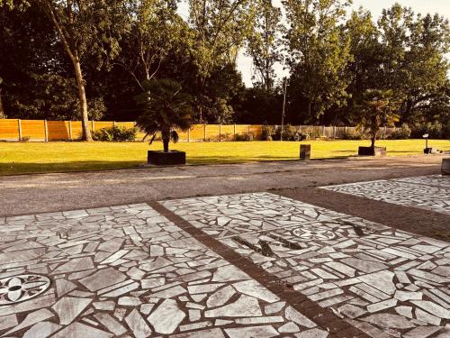a stone walkway with a tree in a park at Cham Crest in Friern Barnet
