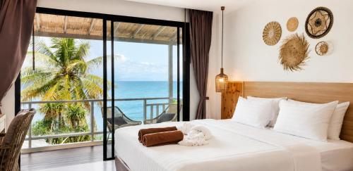 a bedroom with a bed with a view of the ocean at Moonlight Bay Resort in Ko Lanta