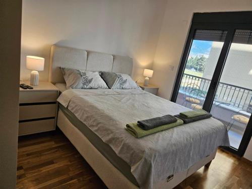 a bedroom with a large bed with two towels on it at Apartman Kiki in Šušanj