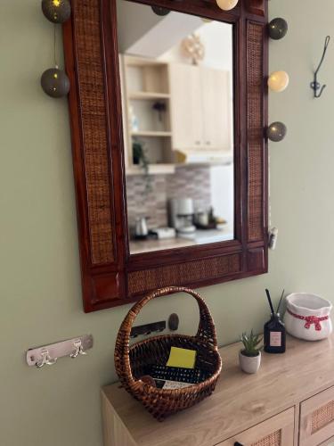 a mirror and a basket on a dresser in a bathroom at Almyra Home in Kyparissia