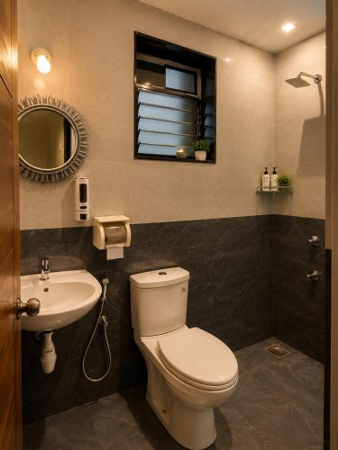 a bathroom with a toilet and a sink and a mirror at Coutinho BNB in Madgaon
