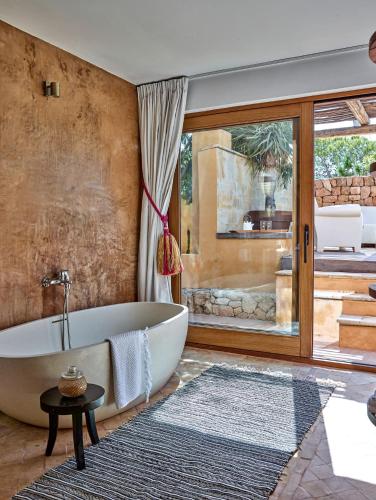 a bathroom with a tub and a large window at Kasbah 3 in Cala Vadella