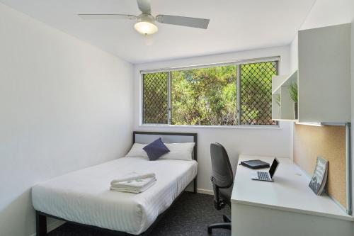 a bedroom with a bed and a desk and a window at Murdoch University Village in Perth