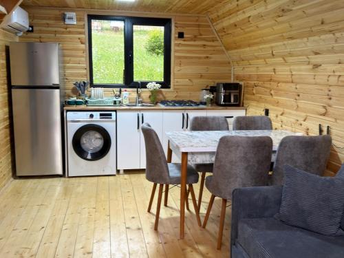 a kitchen with a table with chairs and a refrigerator at რაჭული სიმშვიდე Racha Serenity in Nikortsminda