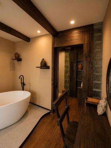 a bathroom with a large white tub and wooden floors at The Mysteri Sapa in Sapa