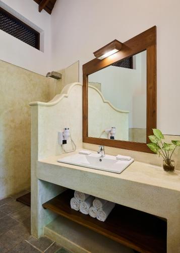 a bathroom with a sink and a mirror at Sri Yoga Shala in Unawatuna
