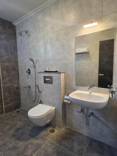 a bathroom with a toilet and a sink at Hotel Srs Manor in Hārohalli