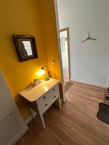 a bathroom with a sink and a mirror on a yellow wall at Rooms in an Apartment with Beautiful Views in Przemyśl