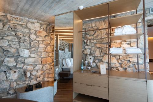 a stone wall in a bathroom with towels at Buzë Boutique Hotel in Sarandë