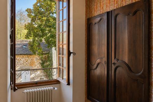 a large wooden door next to a window at La Selva in Busserolles