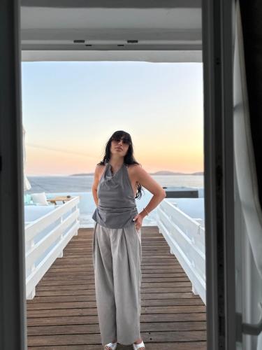 a woman is standing on a boardwalk at Mykonos Moussa in Agios Ioannis Mykonos