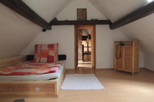 a attic room with a bed and a wooden floor at Ferienhaus Zum Herbertsche in Lemberg