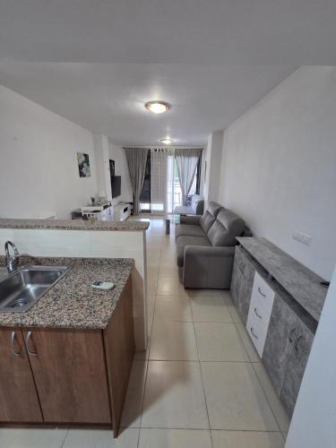 a kitchen with a sink and a couch in a room at Moncofa Beaches Apartment in Moncófar