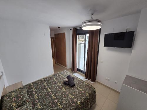 a bedroom with a bed and a television on the wall at Moncofa Beaches Apartment in Moncófar