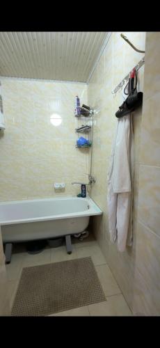 a bathroom with a bath tub and a sink at Felt painting in Kara-Suu