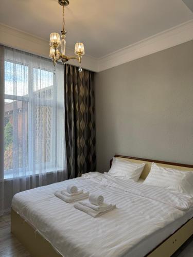 a bedroom with a bed with two towels on it at Cottage on Issyk-Kul, Royal Beach in Chok-Tal