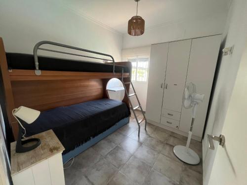 a small room with a bunk bed and a ladder at Casa Playa La Barrosa in Novo Sancti Petri