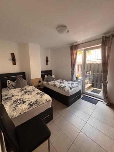 two beds in a room with a window at Am Dollespark in Bodenheim