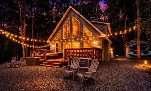 a cabin with chairs and lights in the woods at Brand New Chalet - Seclusion Arcadez Fire Pit in Locust Lakes Village