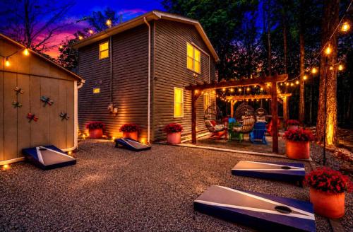 a backyard with a house with lights and a patio at Brand New Chalet - Seclusion Arcadez Fire Pit in Locust Lakes Village