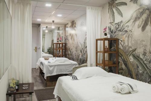 a hospital room with two beds and a mural at Hotel MR Les Rotes in Denia