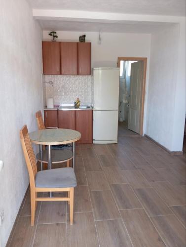 a kitchen with a table and chairs and a refrigerator at Latina lastva in Budva