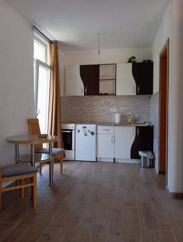 a kitchen with white appliances and a table and chairs at Latina lastva in Budva