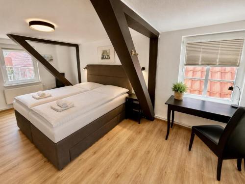 a bedroom with a large bed and a desk at Ferienhaus Maria in Warnemünde
