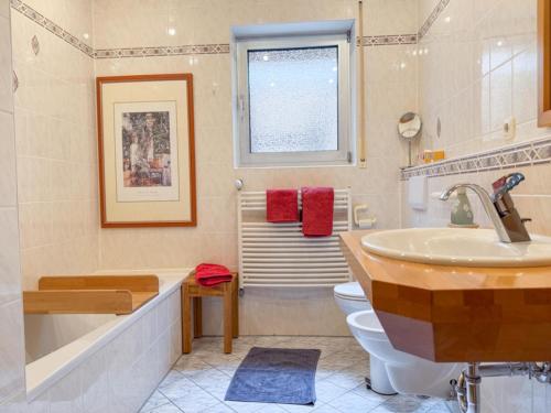 a bathroom with a tub and a toilet and a sink at Ferienwohnung Binder - Ferienwohnung Bad Windsheim in Bad Windsheim