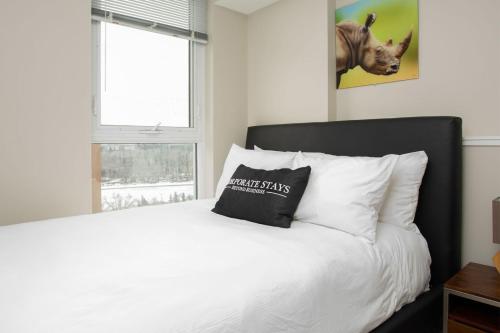 a bedroom with a white bed with a pillow on it at Hendrix Luxury Apartments by Corporate Stays in Edmonton