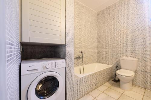 a bathroom with a washing machine and a toilet at Aurora by Mediterra in Isterni