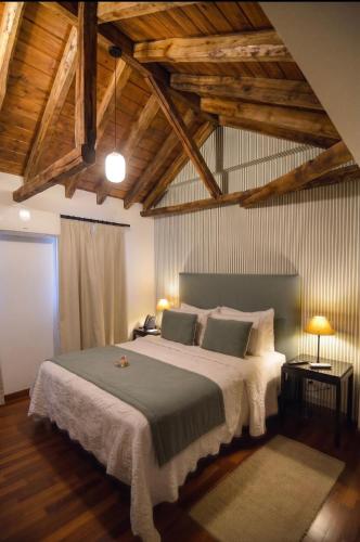 a bedroom with a large bed with wooden ceilings at Casón del Conde in Orgaz