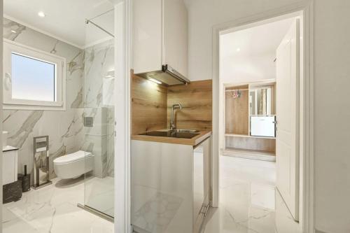 a bathroom with a sink and a toilet and a mirror at Jimmy's by the beach ipsos in Ipsos