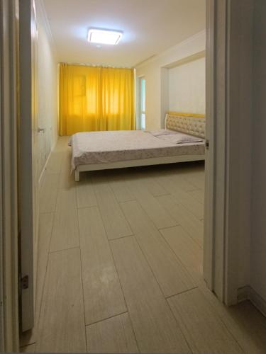 a bedroom with a bed in the middle of a room at Darkhan Apartment in Darhan