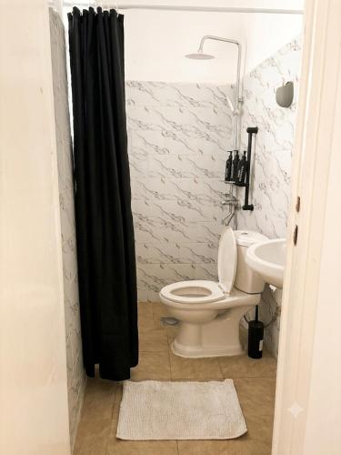 a bathroom with a toilet and a sink at Maison BA à Ouenzé in Brazzaville