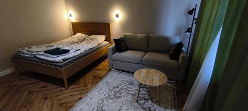 a small room with a bed and a couch at Apartament Sobieskiego in Puck