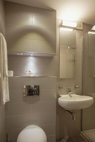 ein Badezimmer mit Waschbecken, Toilette und Spiegel in der Unterkunft Hotel Melodia in Venus