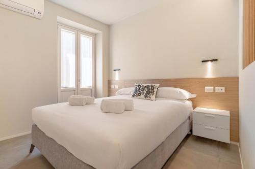 a large white bed in a bedroom with a window at Aromi Piccolo Hotel in Salò