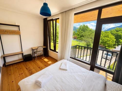 a bedroom with a bed and a large window at Eka's guest house in Mestia