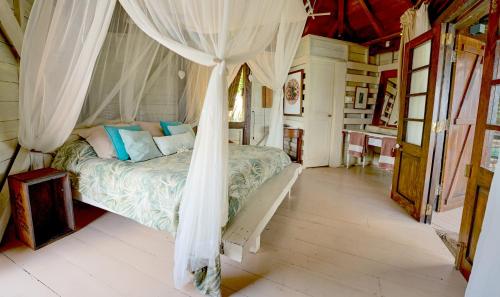 a bedroom with a bed with a canopy at Harmonie in Rivière Noire