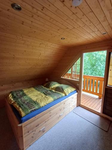a bed in a log cabin with a window at Holiday Home Fleesensee in Göhren-Lebbin