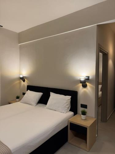 a bedroom with a large white bed and a table at Laki Hotel in Nea Plagia