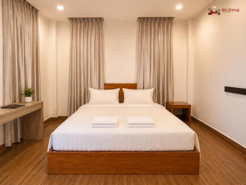 a bedroom with a large bed with white sheets at Ah Gong Boutique Bungalows in Sihanoukville