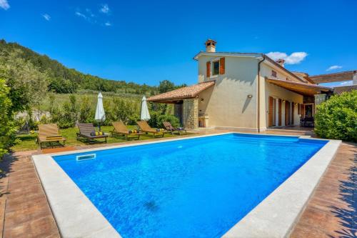 a villa with a swimming pool in front of a house at Villa Dol in Buzet