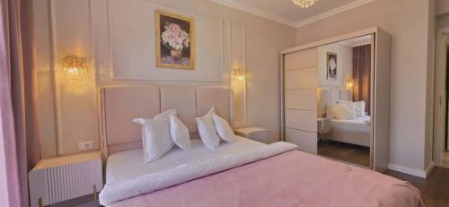 a bedroom with a large bed with white pillows at Apartament Green Tara in Oradea