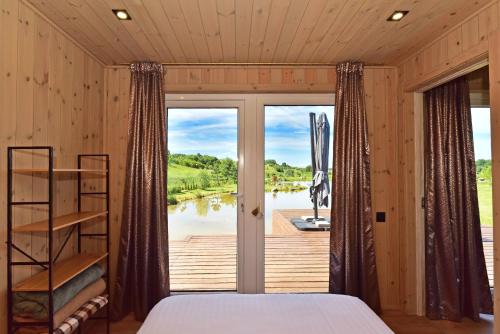 a bedroom with a bed and a large window at Aurora Resort in Stasiūnai