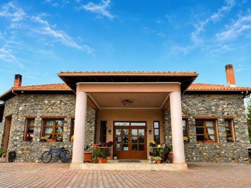 a stone house with a front door and a brick driveway at Hotel Epavlis in Káto Poróïa
