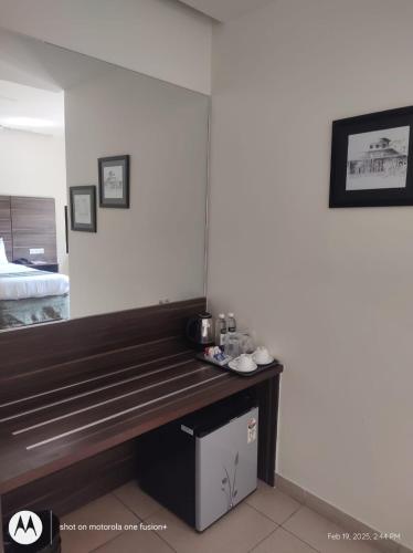 a large wooden bench in a room with a bed at Zentora in Belagula