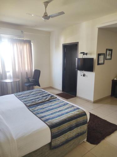 a hotel room with a large bed and a television at Zentora in Belagula
