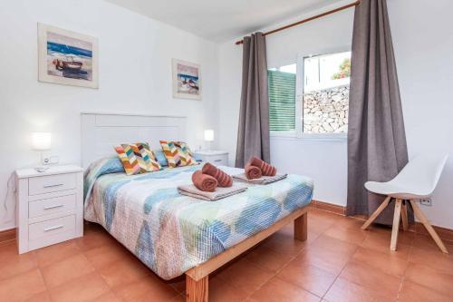 a bedroom with a bed with towels on it at Villa Olga in Cala en Porter